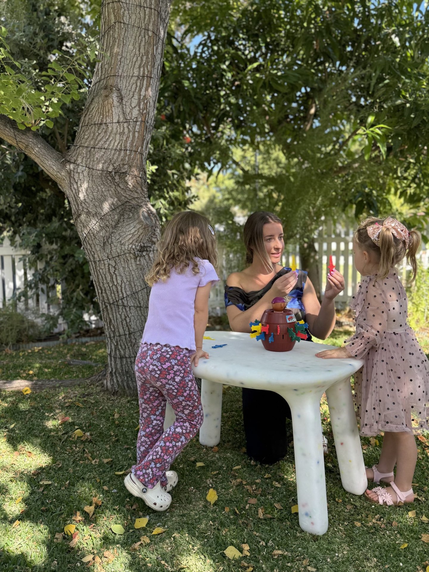 Speech pathologist guiding two children through a turn-taking game
